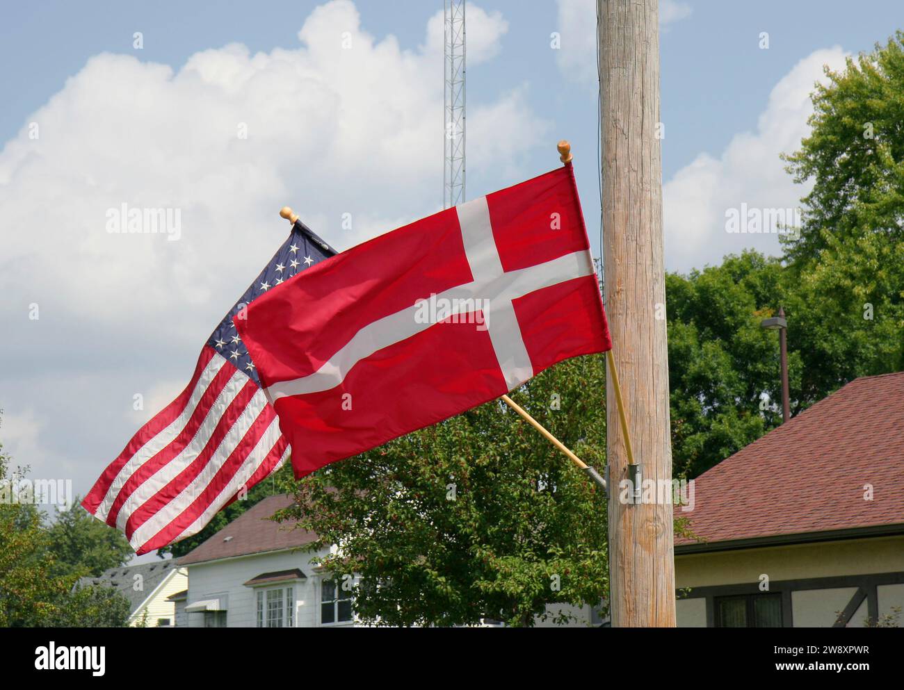 Banderas de EE.UU. Y Dinamarca volando en el aire en el poste de madera en Elk Horn, Iowa Foto de stock