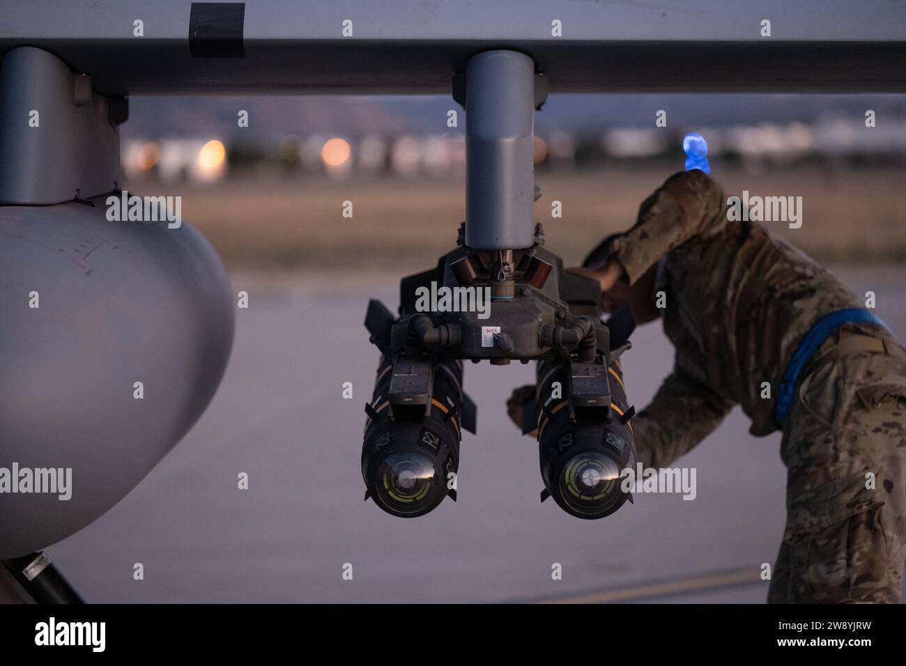 Un encargado de la Guardia Nacional Aérea de los Estados Unidos asignado al Ala de Ataque 163d (ATKW) verifica las correas de misiles AGM-114 Hellfire para una correcta puesta a tierra en la plataforma de carga caliente en la Base de la Reserva Aérea de Marzo en California, 10 de diciembre de 2023. La Agencia de Defensa de Misiles de los Estados Unidos llevó a cabo una interceptación exitosa de un misil balístico de alcance intermedio (IRBM) por un Interceptor Basado en Tierra (GBI) mejorado. La prueba demostró la capacidad de la defensa de curso medio (GMD) basada en tierra para atacar las amenazas más rápido. El 163d ATKW se encargó de ayudar al lanzamiento localizando el cohete caído y asegurándolo seguro Foto de stock