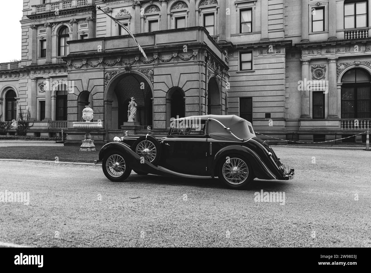 Un coche clásico vintage está estacionado frente a un edificio histórico. Audrain Car Show Foto de stock