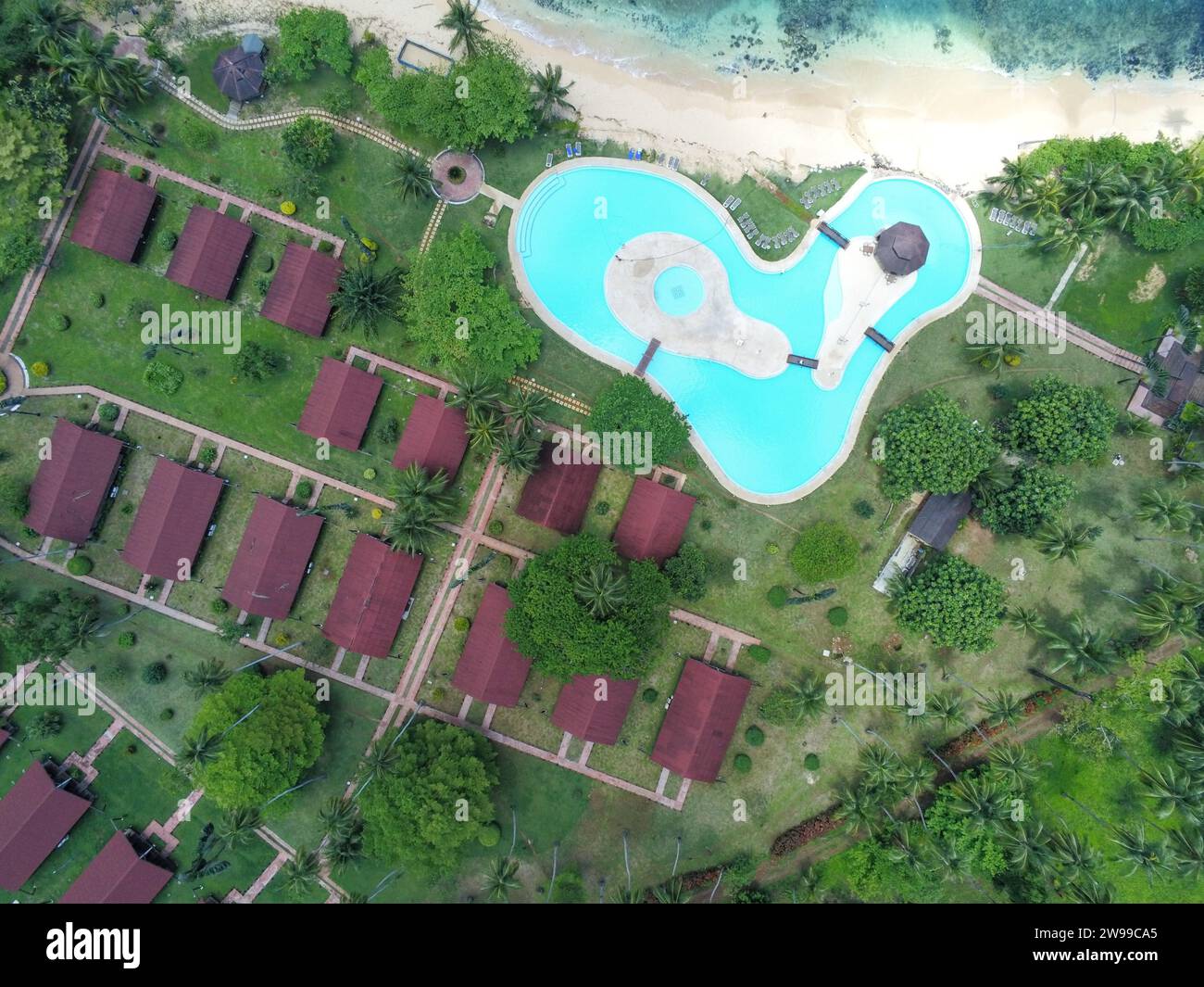 Vista aérea sobre una piscina en forma de corazón y bungalows en la isla Ilheu das Rolas, Santo Tomé y Príncipe, África Foto de stock