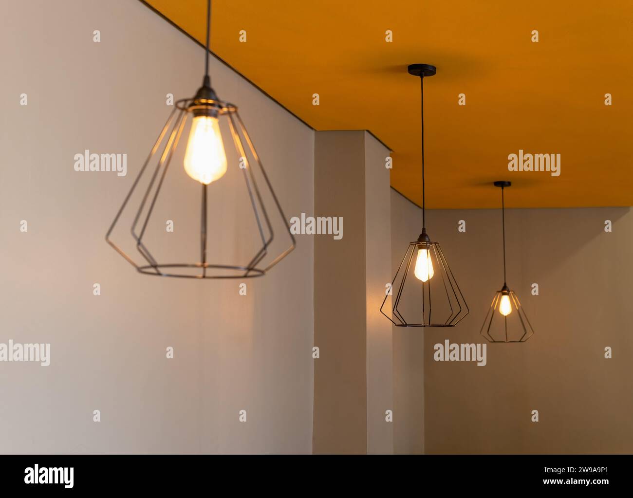 luces de diseño, sala de iluminación naranja, lámparas de alambre simples Foto de stock