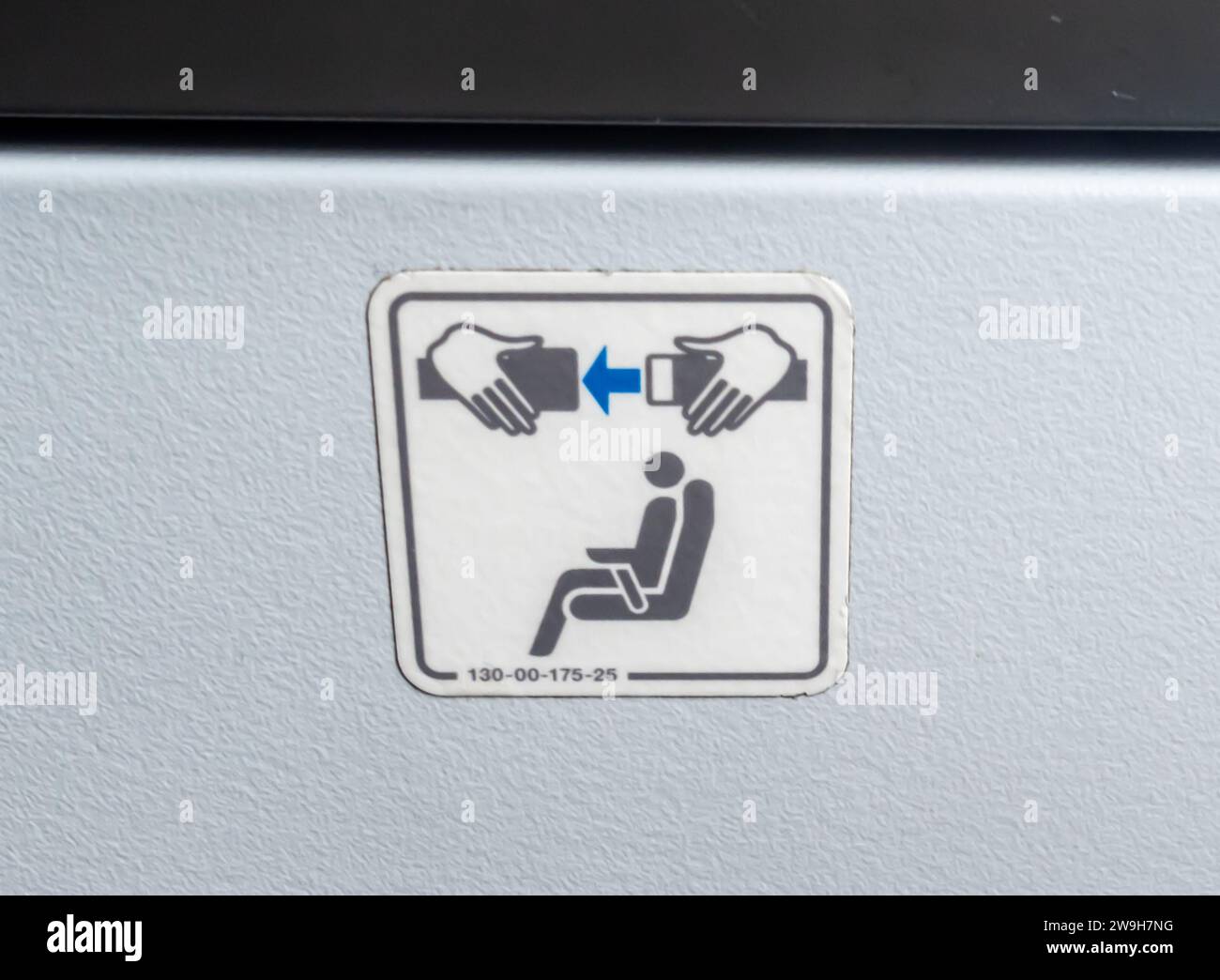 Gráficos del asiento del avión ADVERTENCIA para sujetar un cinturón de seguridad en un avión Foto de stock