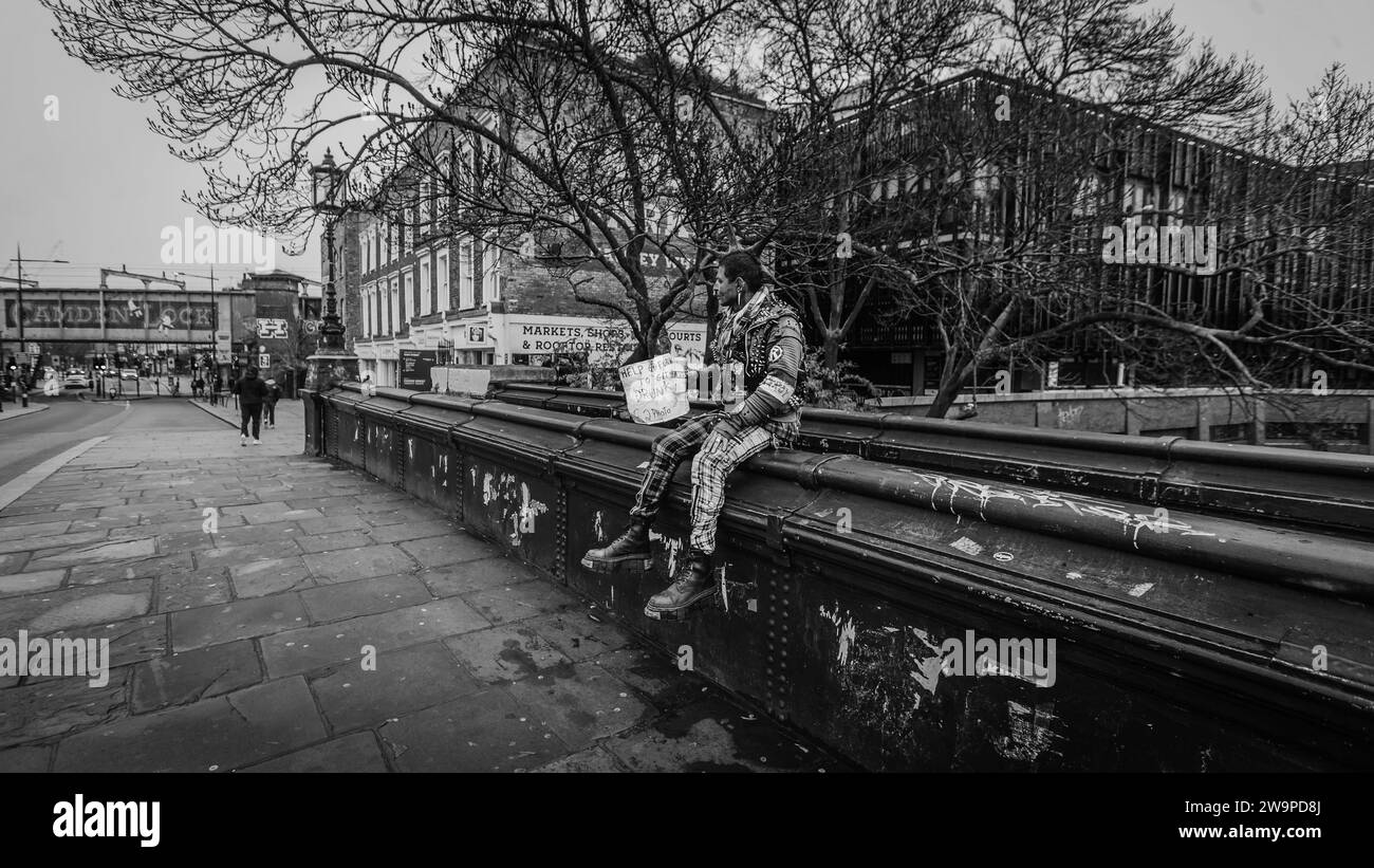 Un punk solitario se relaja en el puente Lockside en Camden en Navidad. Foto de stock