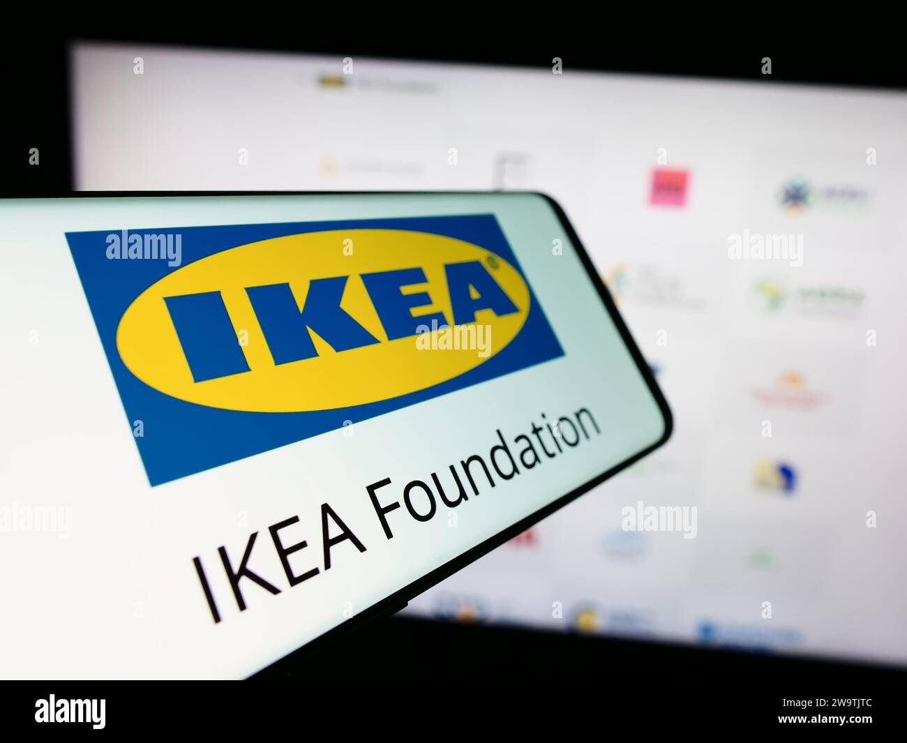 Teléfono móvil con logo de la organización Fundación IKEA delante de la