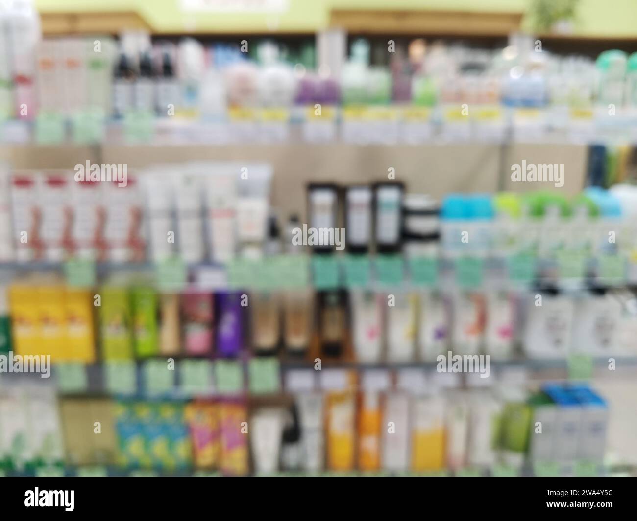 Fondo borroso con estantes con productos para el cuidado de la piel y el cabello en una tienda de cosméticos. Rack con estantes con cosméticos en una tienda. Foto de stock