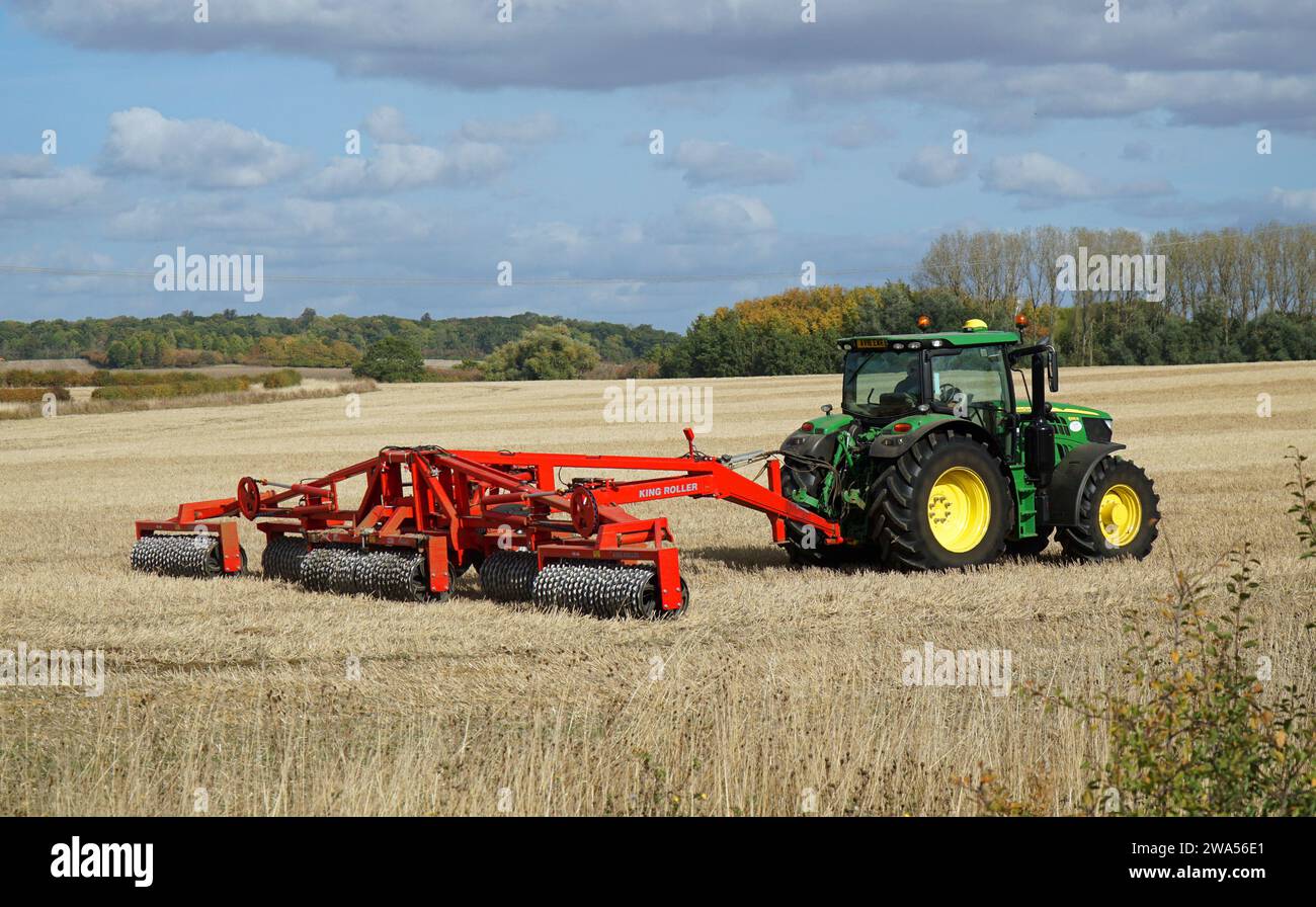 Tractor en campo con King Roller Suelo embalaje en día soleado Foto de stock