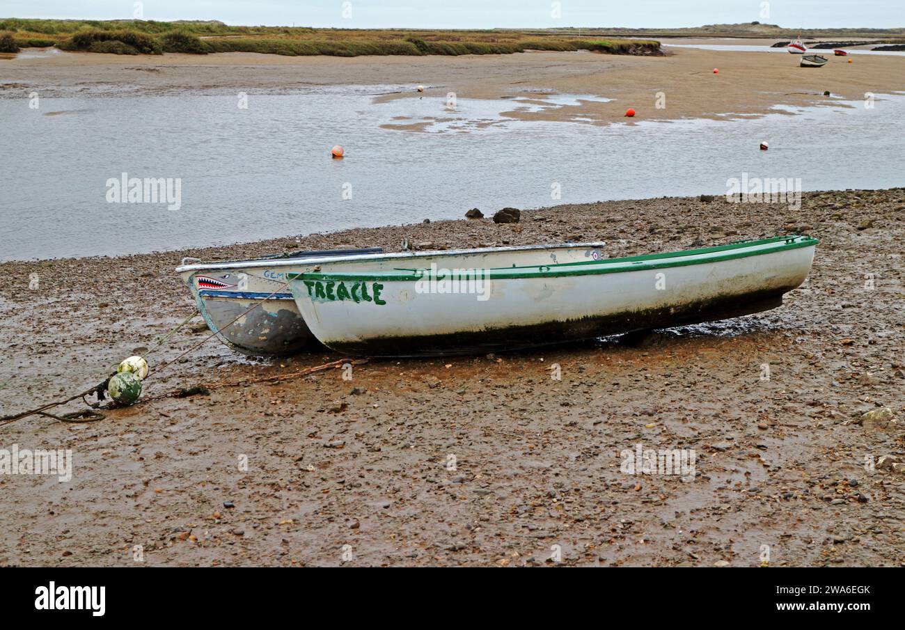 Dos pequeñas embarcaciones de ocio varadas y amarradas en aguas bajas en la costa norte de Norfolk en Burnham Overy Staithe, Norfolk. Inglaterra, Reino Unido. Foto de stock
