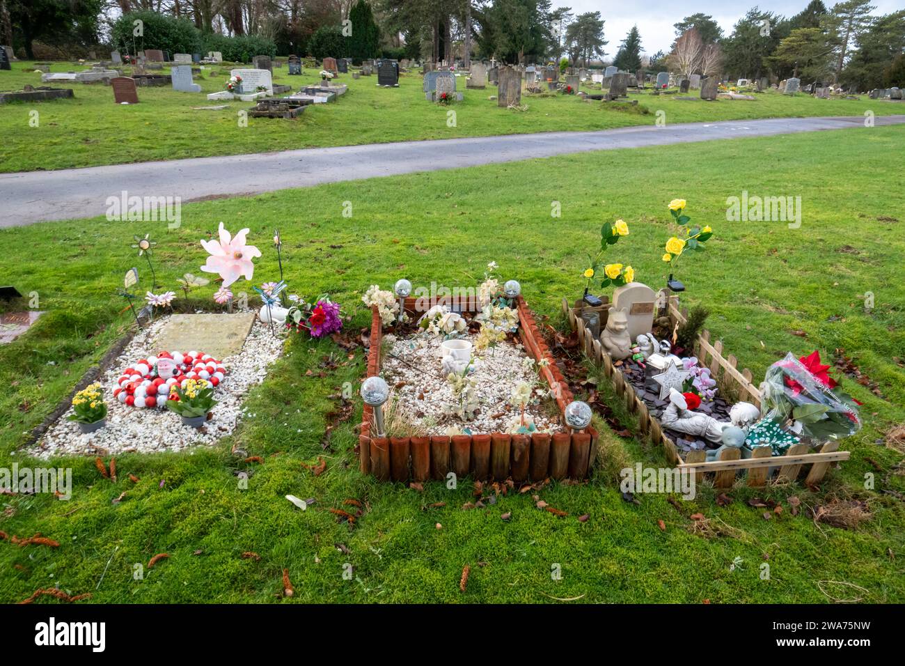 Tumbas infantiles en el cementerio Magdalen Hill, Winchester, Inglaterra, Reino Unido. Tumbas de bebés bebés bebés bebés niños pequeños con juguetes y decoraciones. Foto de stock