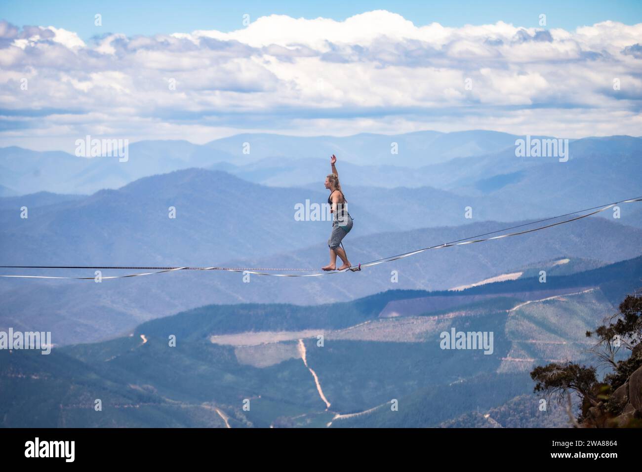 Slacklining a través de los Alpes Australianos. Un slackliner que equilibra alto en Mount Buffalo en Victoria, Australia. Foto de stock