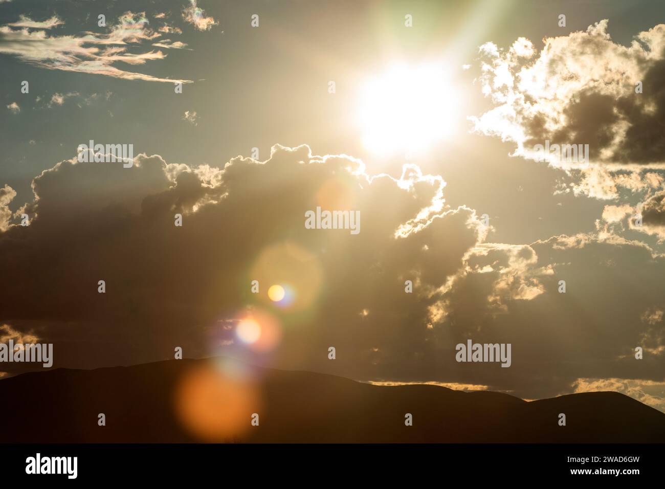 Destello de la lente del sol de la tarde y las nubes en el cielo Foto de stock