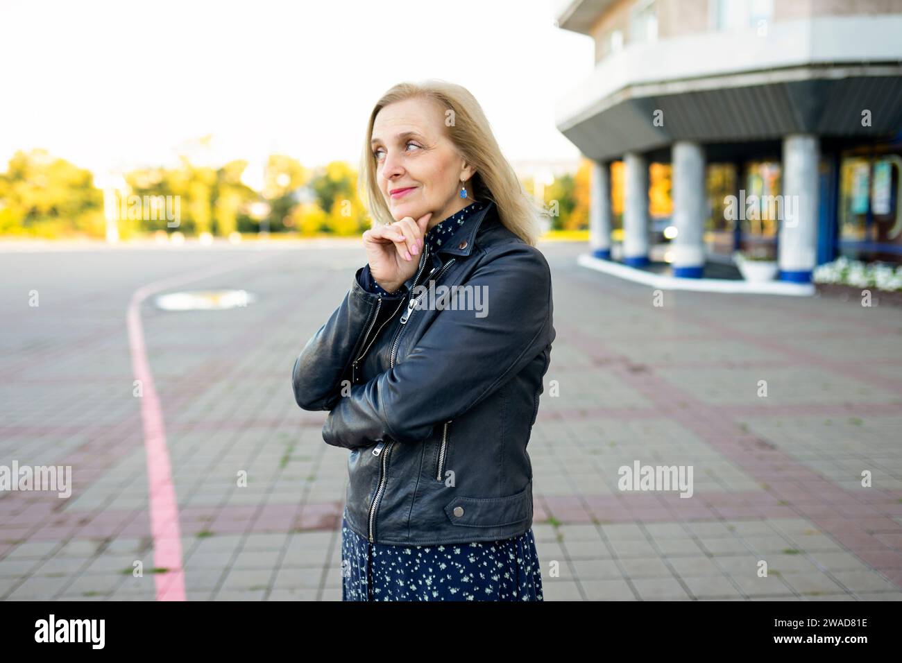 Retrato de mujer pensativa de pie frente al edificio Foto de stock