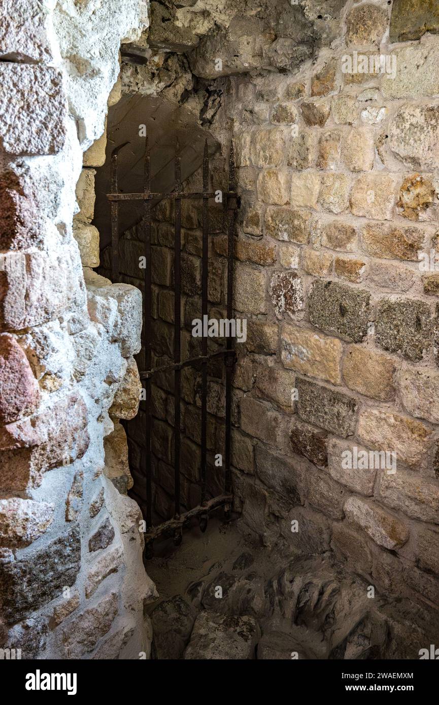 Detalle de una cueva secreta de la Abadía del Mont Saint Michel, se cierra con una puerta hecha de barras de hierro forjado Foto de stock
