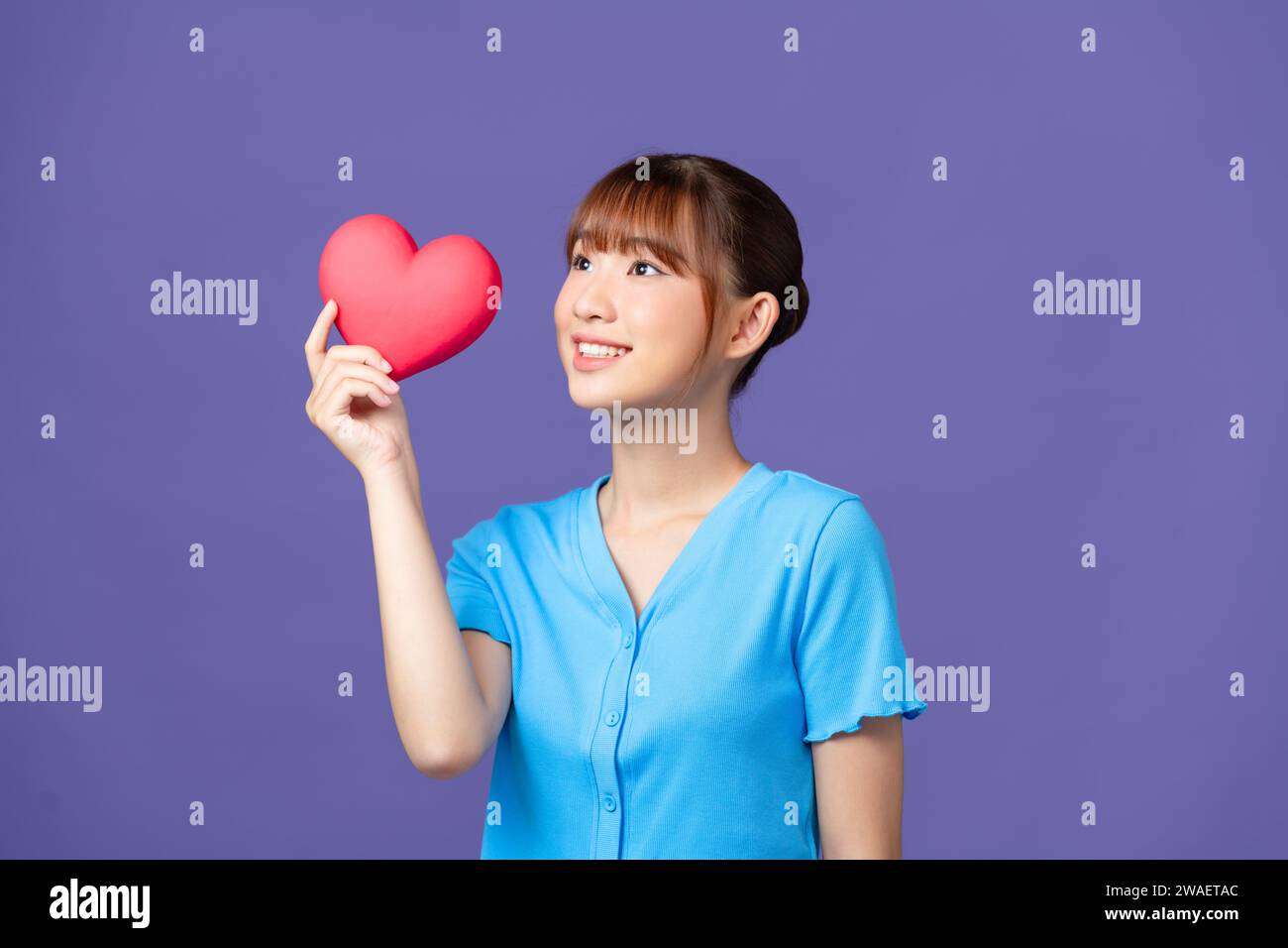 Hermosa señora asiática sosteniendo un corazón rojo en las manos Foto de stock