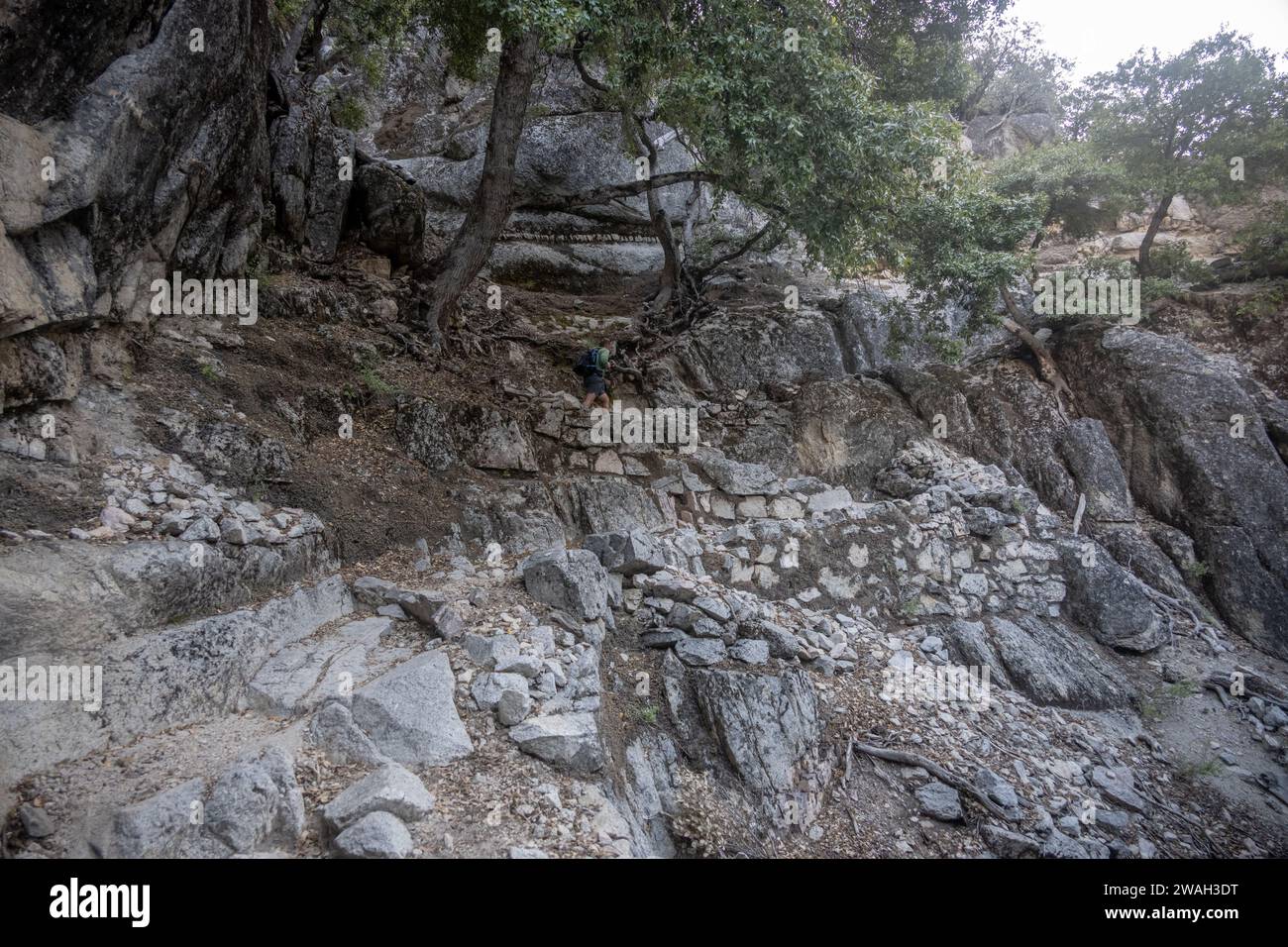 El hombre sube empinadas curvas en el Snow Creek Trail en el Parque Nacional Yosemite Foto de stock