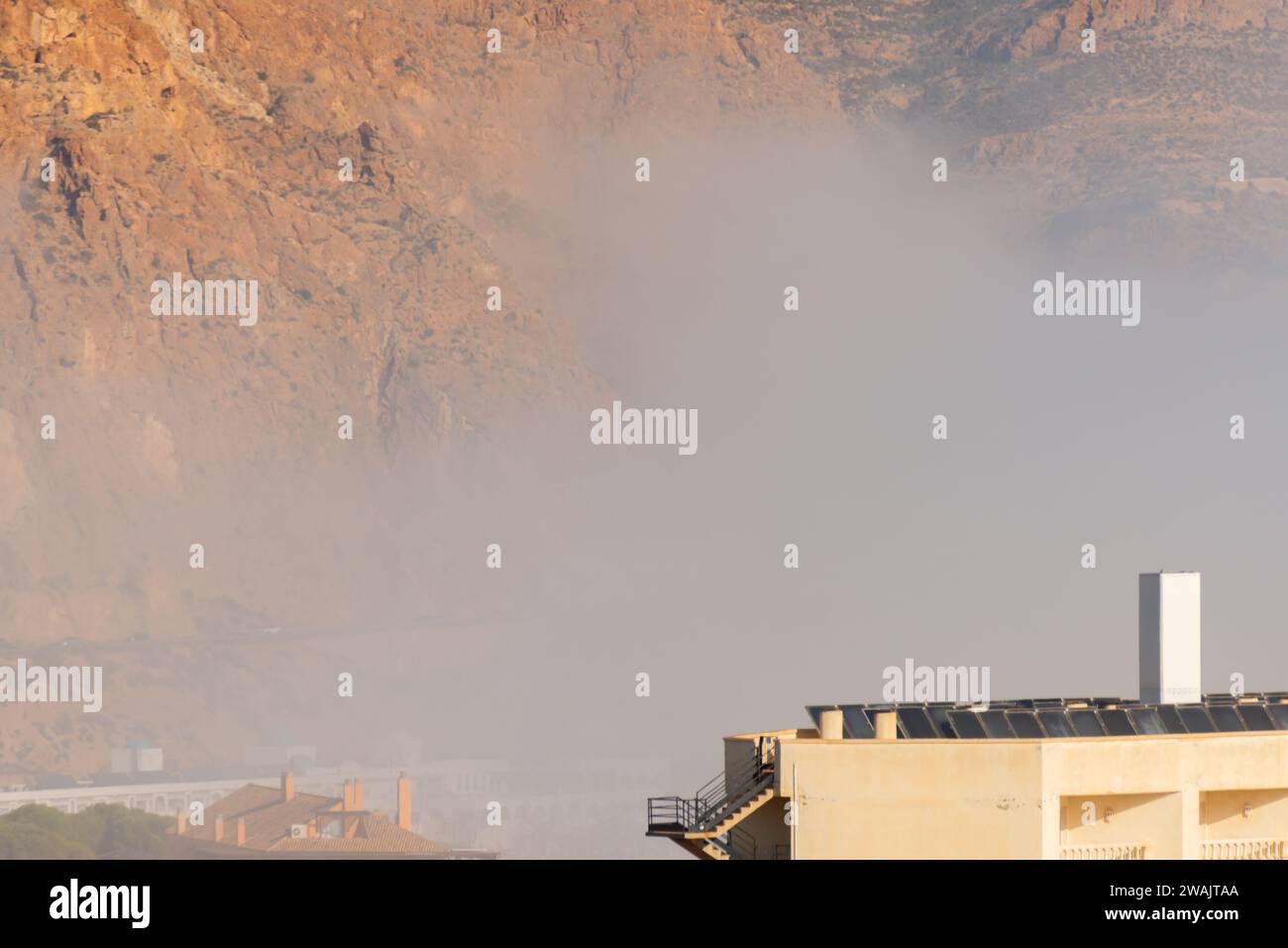 AGUADULCE, ESPAÑA - 12 DE DICIEMBRE de 2023 Niebla que cuelga sobre una ciudad costera en España, vista del paseo marítimo, la franja costera y el mar Mediterráneo en el Andalu Foto de stock