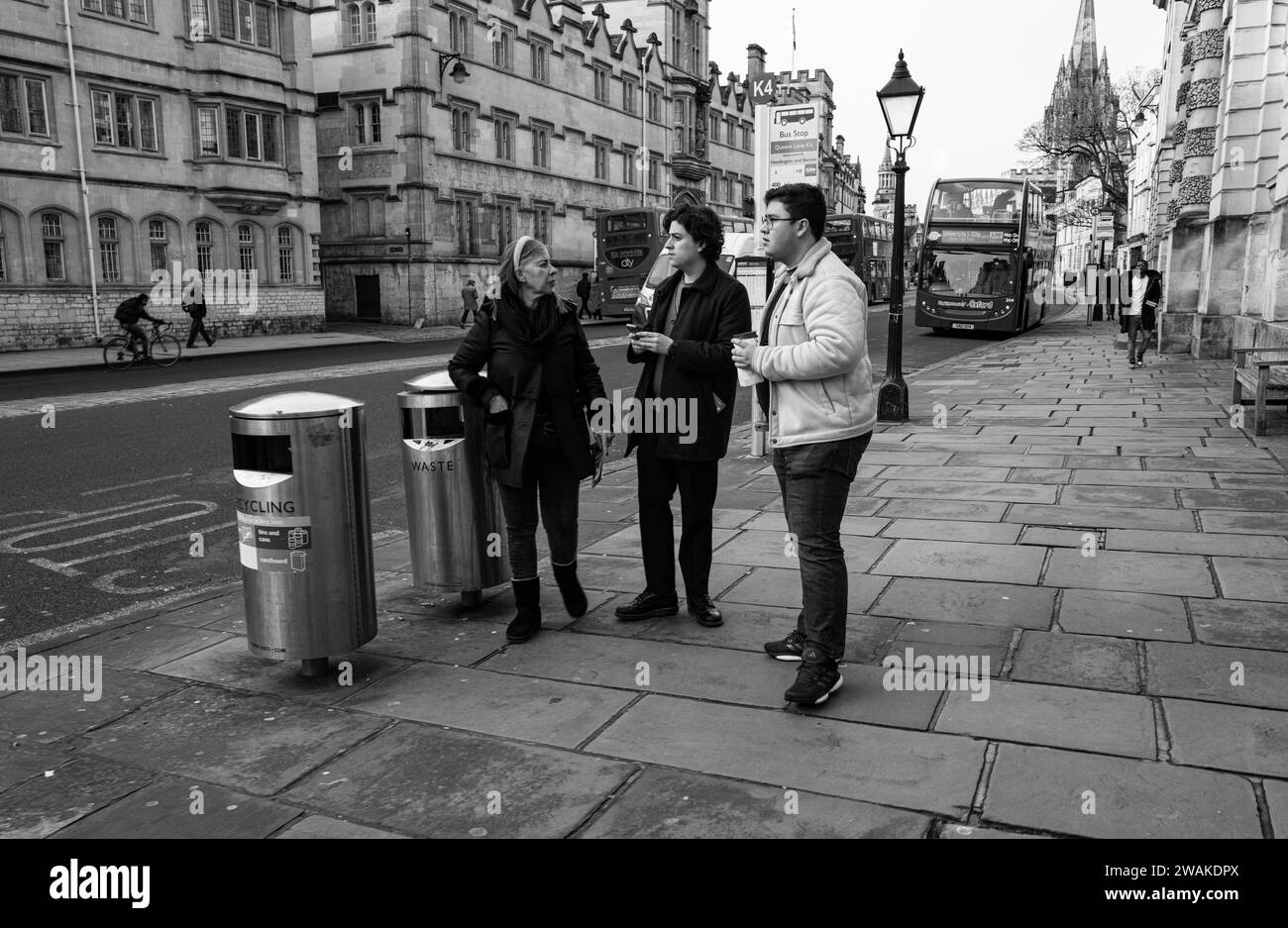 Gente charlando en la parada de autobús por Queens College, Oxford, Inglaterra Foto de stock