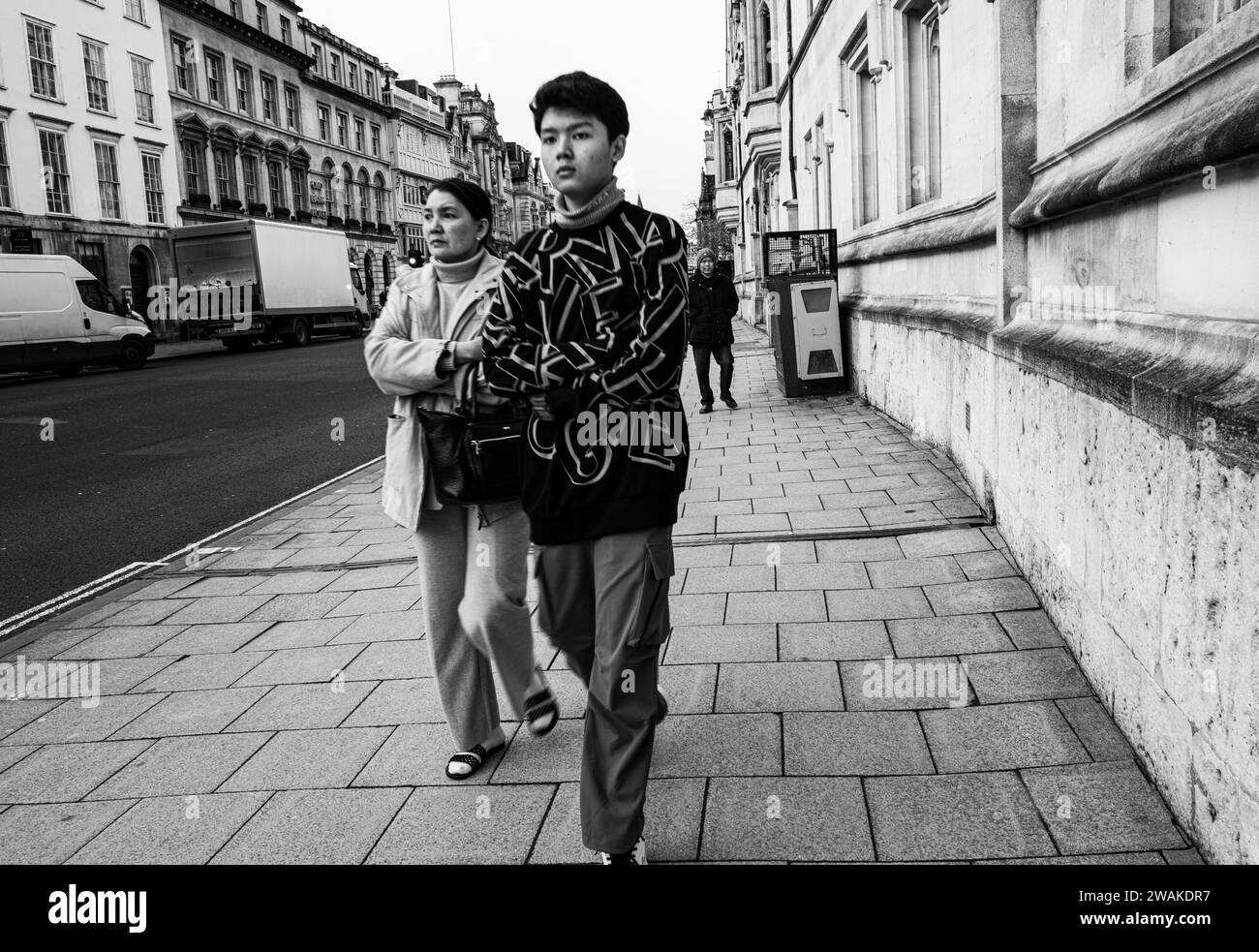 Gente en la calle High Street, Oxford, Inglaterra, por Queens College Foto de stock