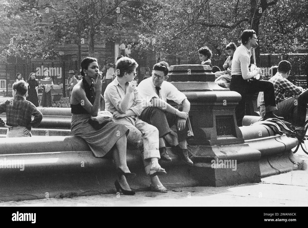 Grupo de personas reunidas alrededor de la fuente, Washington Square Park, Nueva York, Nueva York, EE.UU., Angelo Rizzuto, Colección Anthony Angel, septiembre de 1953 Foto de stock