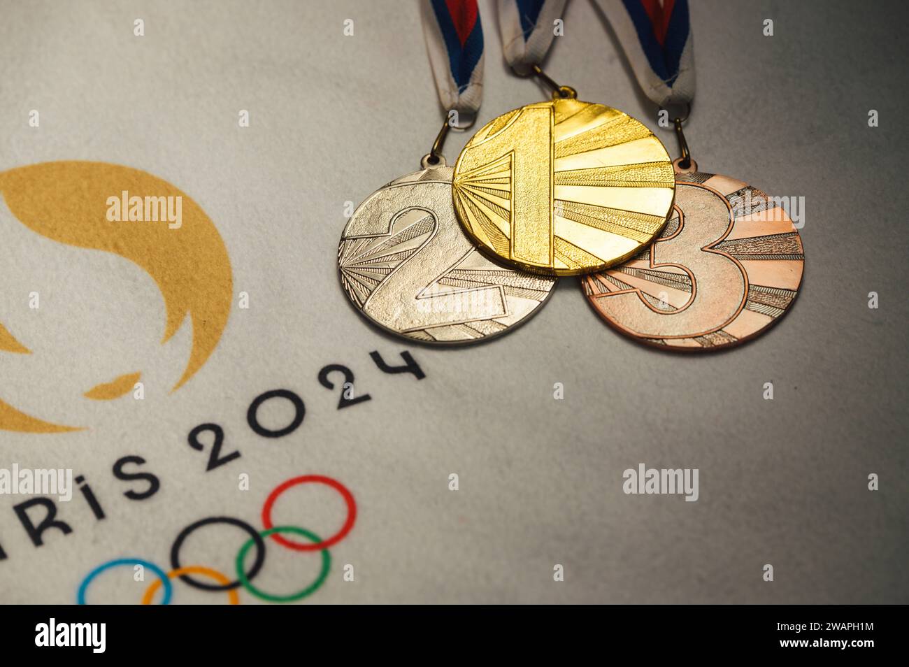 PARÍS, FRANCIA, 4 DE ENERO. 2024: Exhibición exclusiva: Logotipo oficial de los Juegos Olímpicos de Verano de París 2024 en manta blanca con medallas de oro, plata y bronce Foto de stock