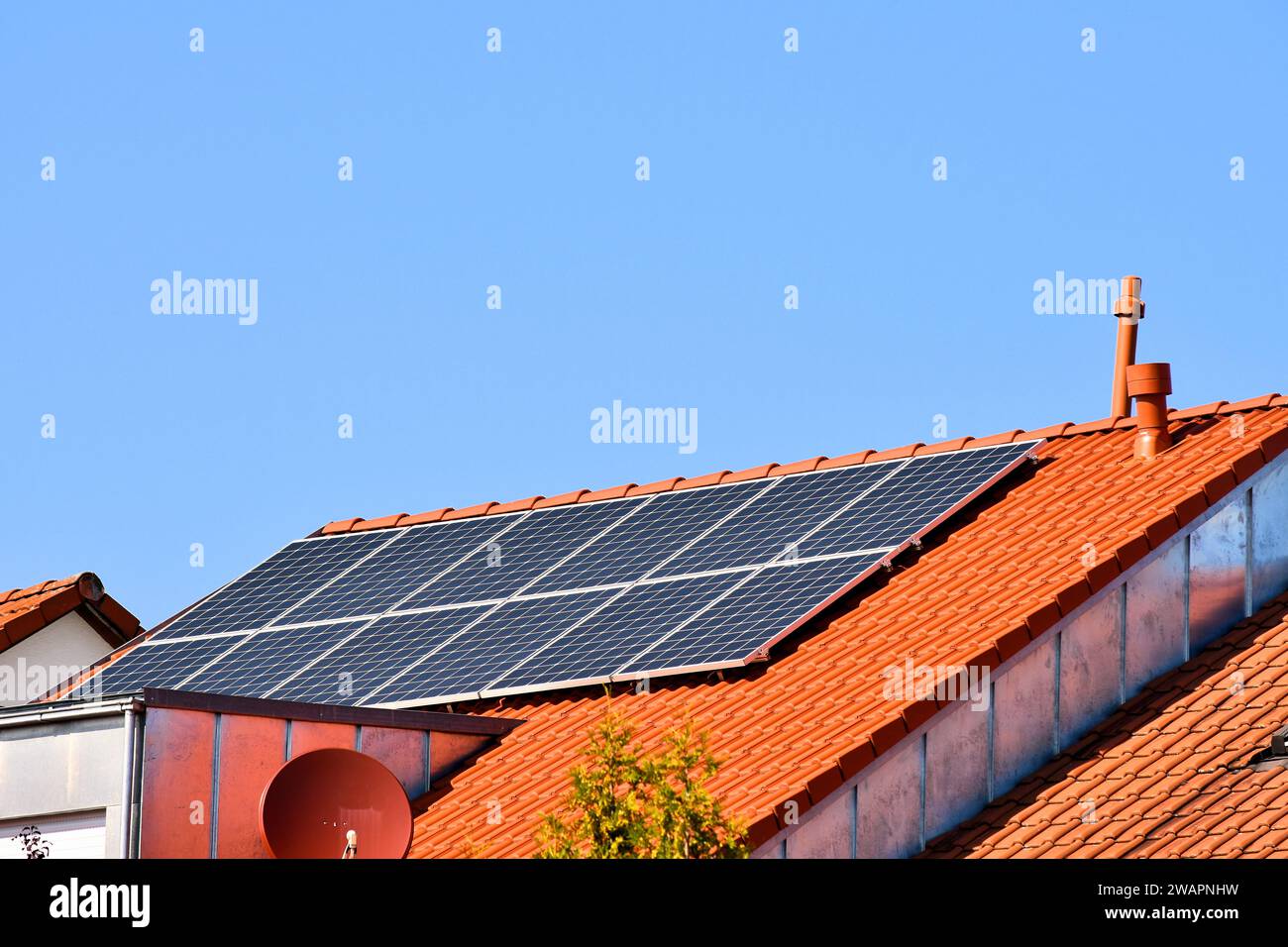 Células solares en una casa unifamiliar para la generación de energía respetuosa con el medio ambiente Foto de stock