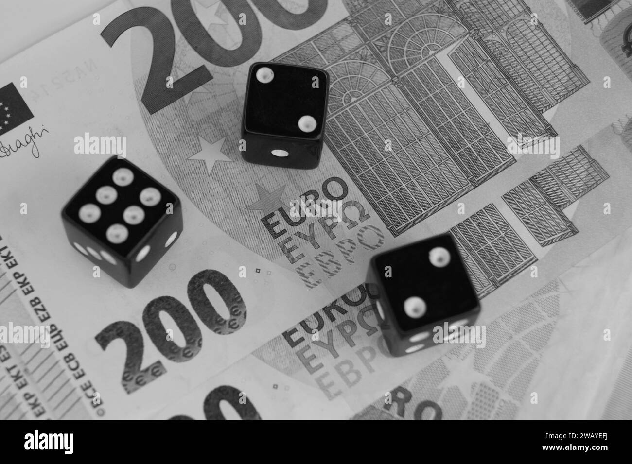 Tres dados en los nuevos billetes de 200 euros, cerca. Imagen en blanco y negro. Foto de stock