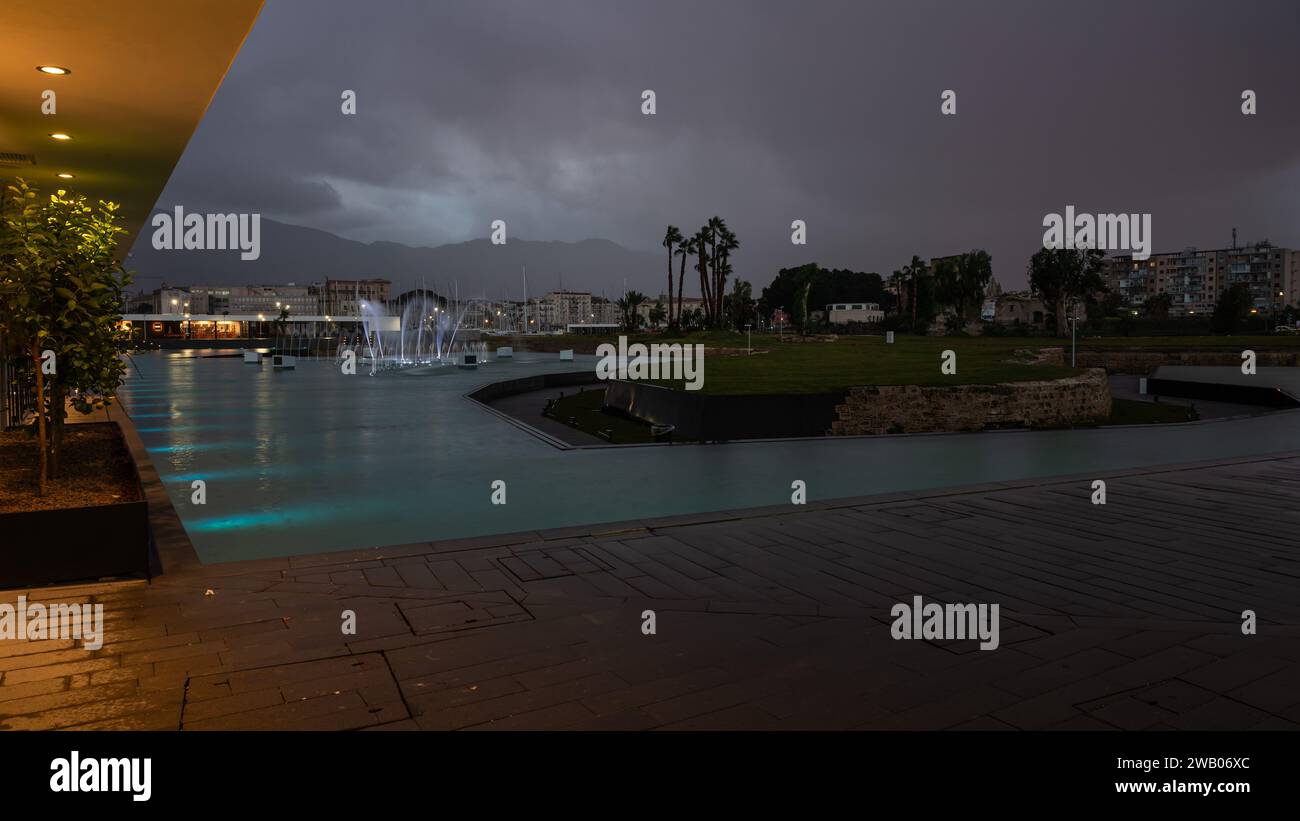 Palmero, Sicilia, Italia, 16 de diciembre de 2023 - Lujo restaurante y fuente durante el crepúsculo en el puerto de Palermo Foto de stock