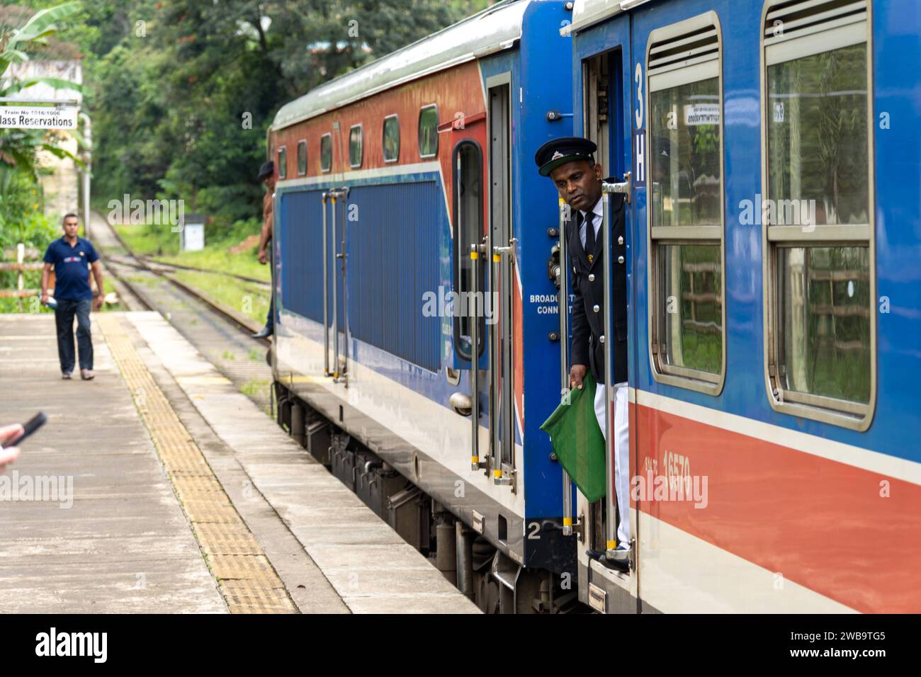 Ella, Sri Lanka, Asia - 19 de diciembre de 2023: Estación de tren de Ella en Sri Lanka. Un conductor ondea para la salida de un tren *** Bahnhof von Ella auf Sri Lanka. Acerca de Ein Schaffner winkt zur Abfahrt von einem Zug Foto de stock