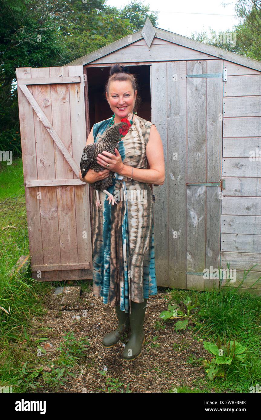 Hembra madura sosteniendo su pollo mascota - John Gollop Foto de stock