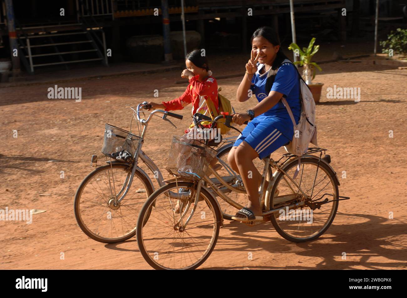 Niños pequeños en bicicleta a casa desde la escuela, Beng Mealea, Camboya. Foto de stock