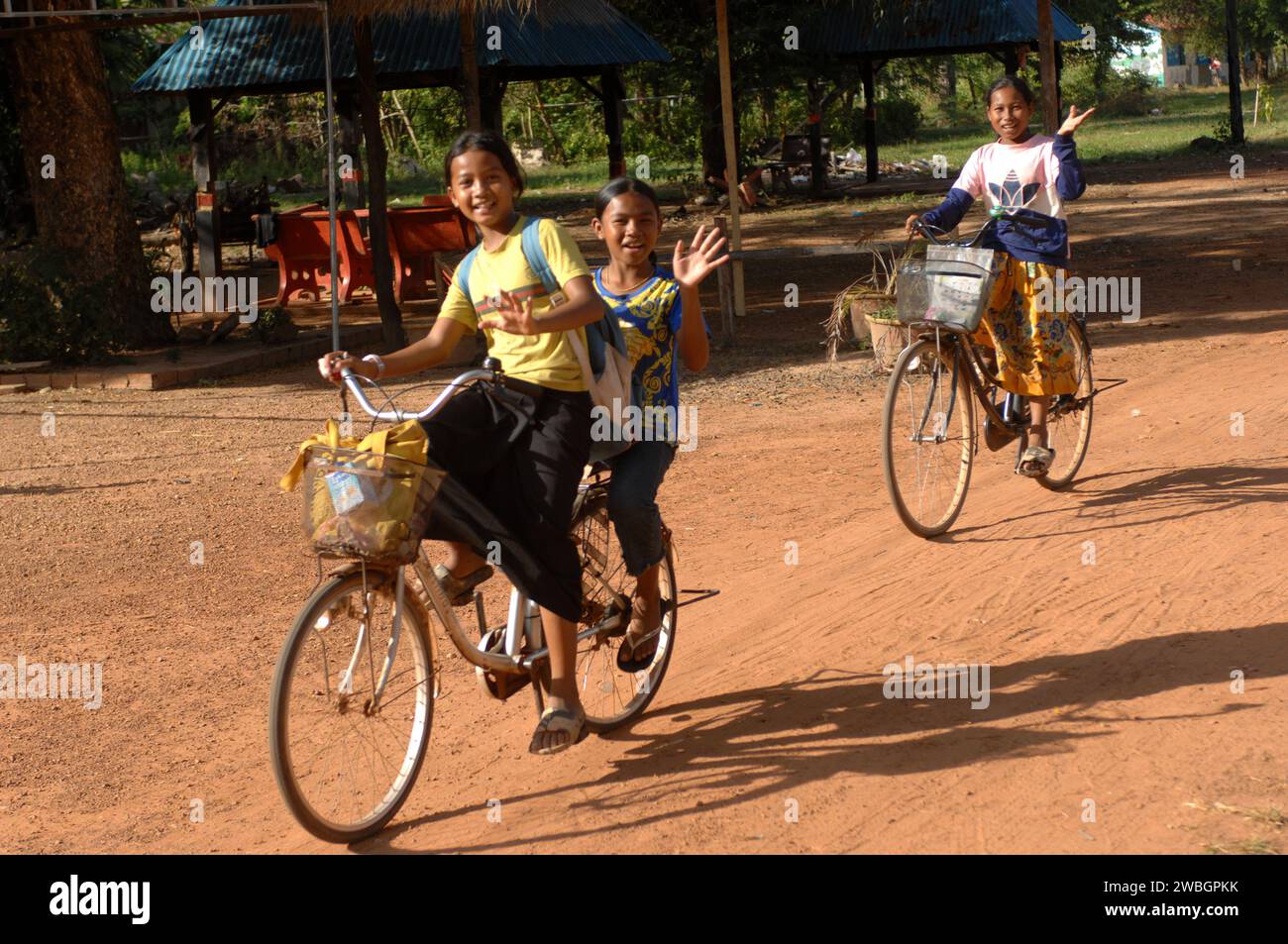 Niños pequeños en bicicleta a casa desde la escuela, Beng Mealea, Camboya. Foto de stock