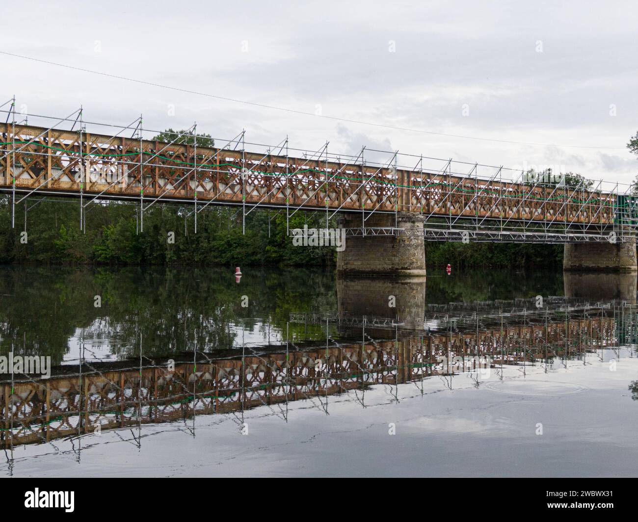 Andamios utilizados para trabajos de mantenimiento o restauración en un pequeño puente sobre un gran río el Cher Foto de stock