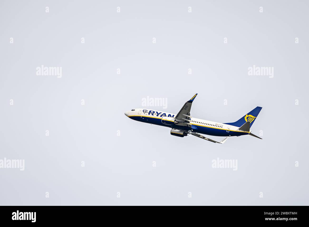 Un avión de pasajeros de una conocida compañía aérea ascendiendo en un cielo sin nubes Foto de stock