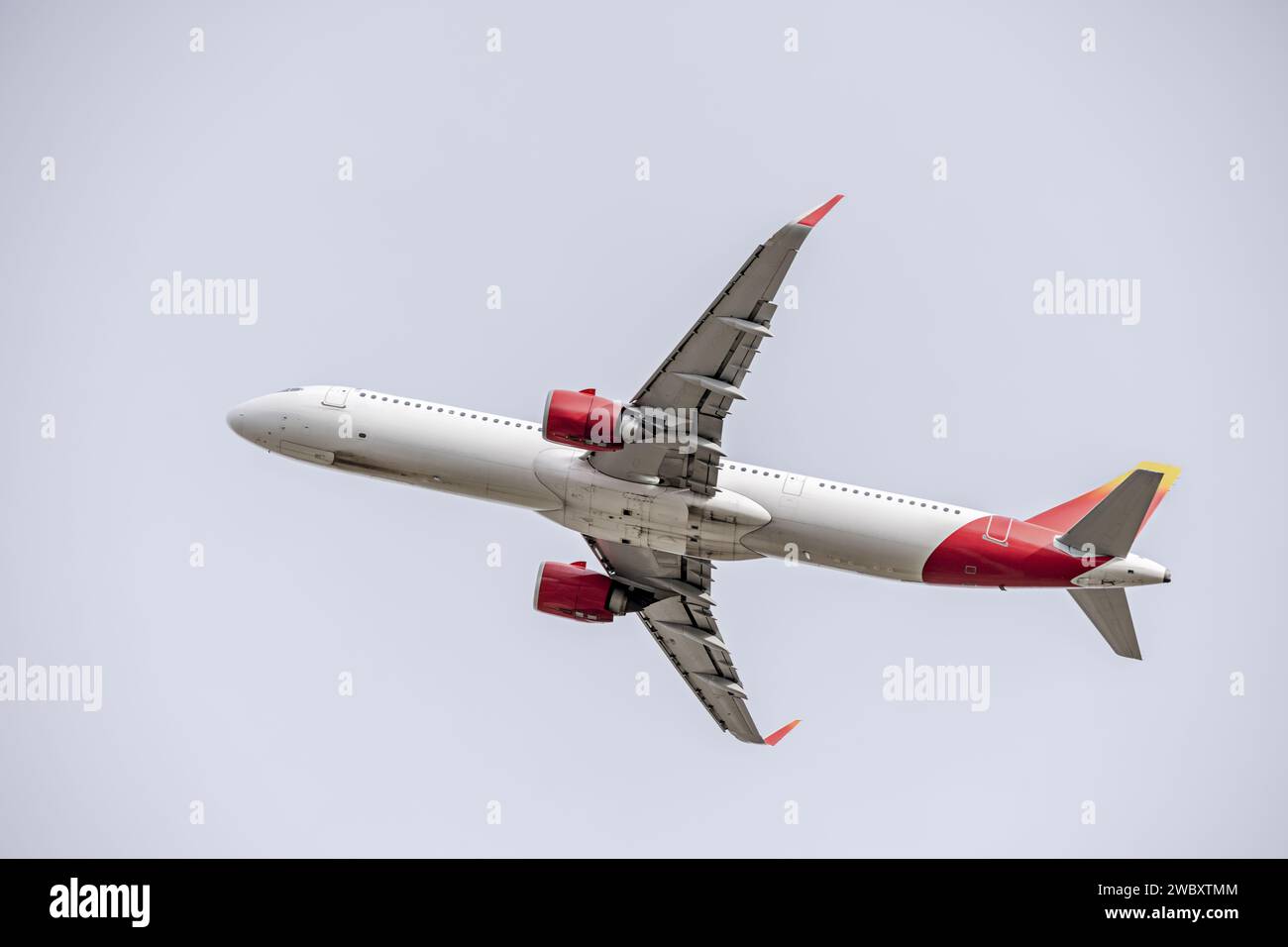 Un avión de pasajeros ascendiendo en un cielo claro Foto de stock