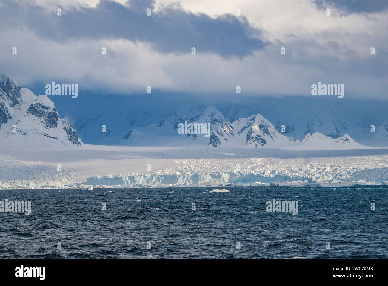 Brialmont Cove, antártida En un día nublado en primavera, hielo y la costa cubierta de nieve con arcos de hielo y cuevas nubes de la antártida claro, cielo azul Foto de stock