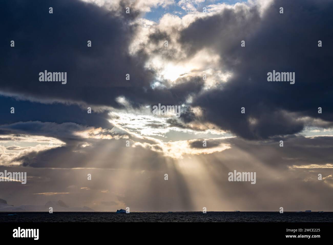 el sol que penetra a través de las nubes en Brialmont Cove, Anarctica Foto de stock