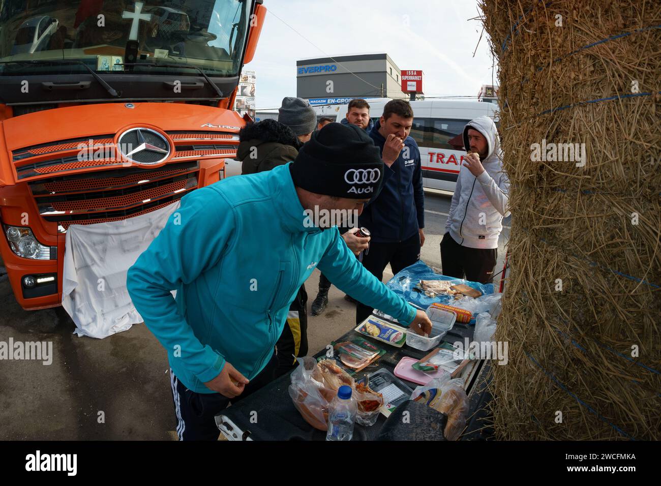 Afumati, Rumanía - 15 de enero de 2024: Conductores rumanos comen durante las protestas de los transportistas y los agricultores, en la comuna de Afumati, a 12 km al norte de Bucarest. Están protestando en contra de los altos precios de los seguros, las tasas impositivas, las largas esperas para cruzar las fronteras, exigiendo facilidades fiscales, simplificación de la legislación, el pago más rápido de subsidios a los agricultores afectados por la sequía o las pérdidas causadas por las importaciones de granos de Ucrania. Crédito: Lucian Alecu/Alamy Live News Foto de stock