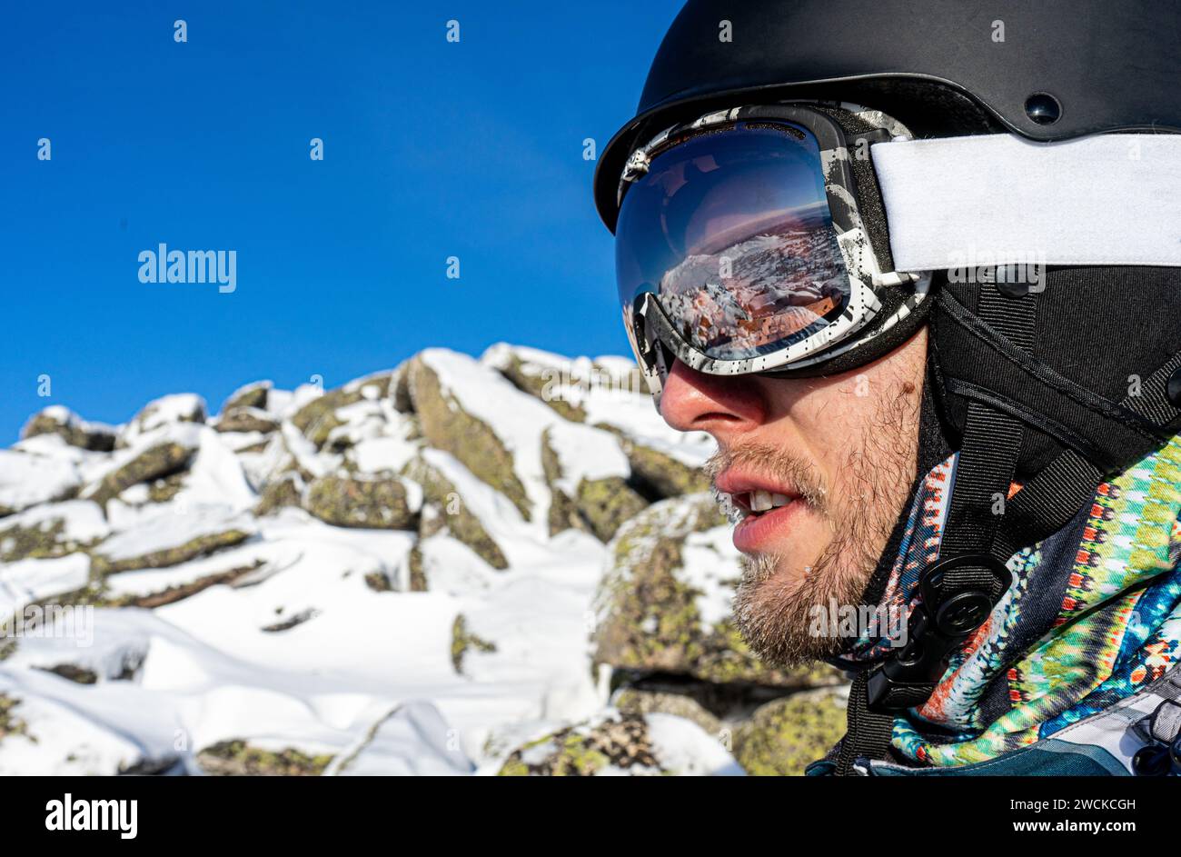 Gafas de esquí con el reflejo de las montañas nevadas. Hombre en el cielo  azul de fondo. Deportes de invierno Fotografía de stock - Alamy