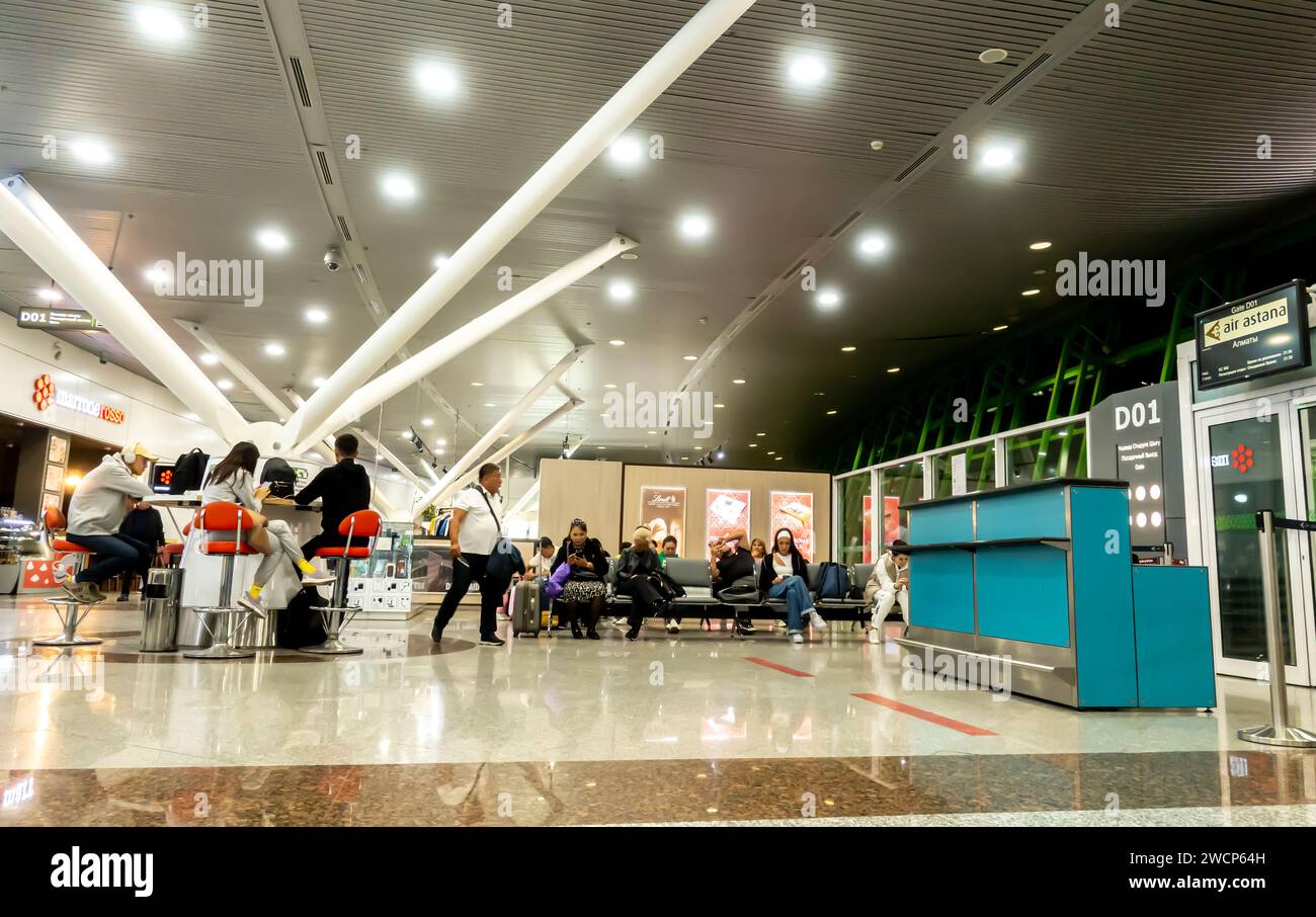 Terminal de salida del aeropuerto de Astana, área de espera con la gente en el aeropuerto de Astana Kazajstán Foto de stock