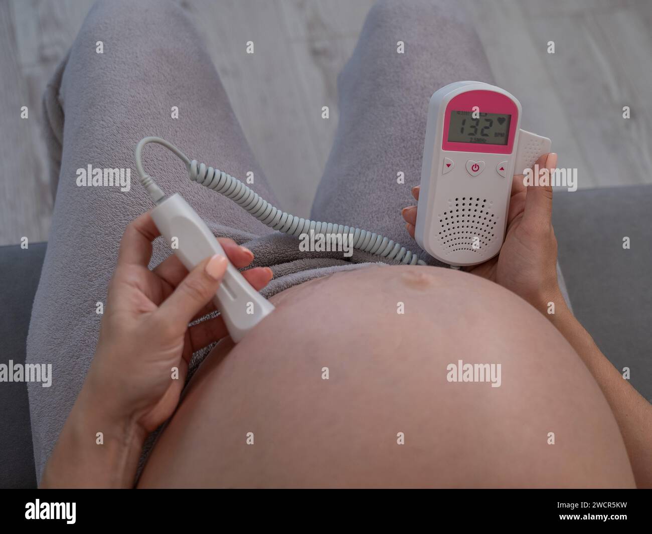 Doppler Fetal para escuchar los latidos del corazón de una mujer embarazada  de un niño y una imagen de una ecografía del embarazo, primer plano, fondo  de color rosa, pregnan Fotografía de