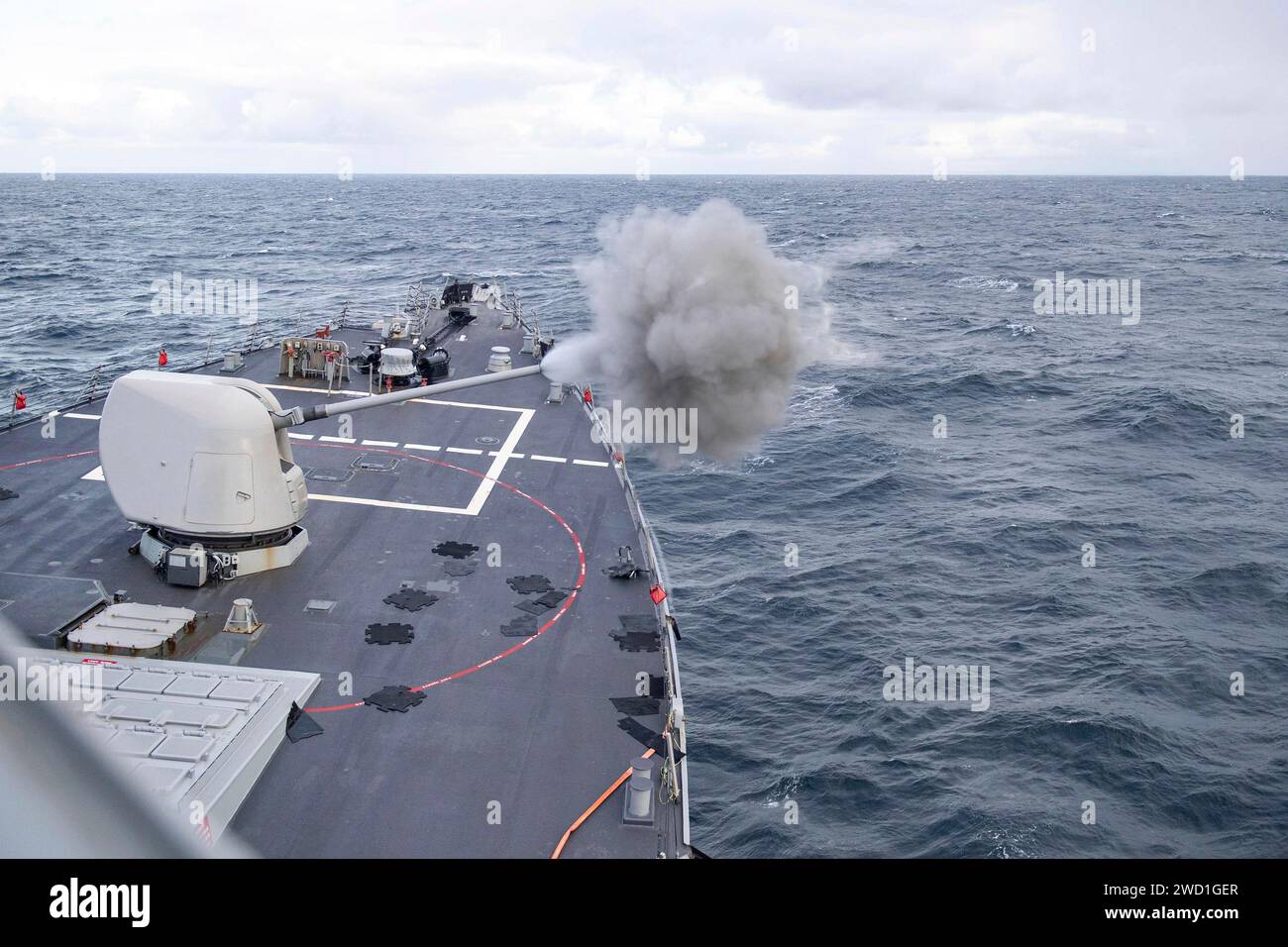 El destructor de misiles guiados USS Rossconduce un ejercicio de fuego real de 5 pulgadas en el estrecho de Minch. Foto de stock