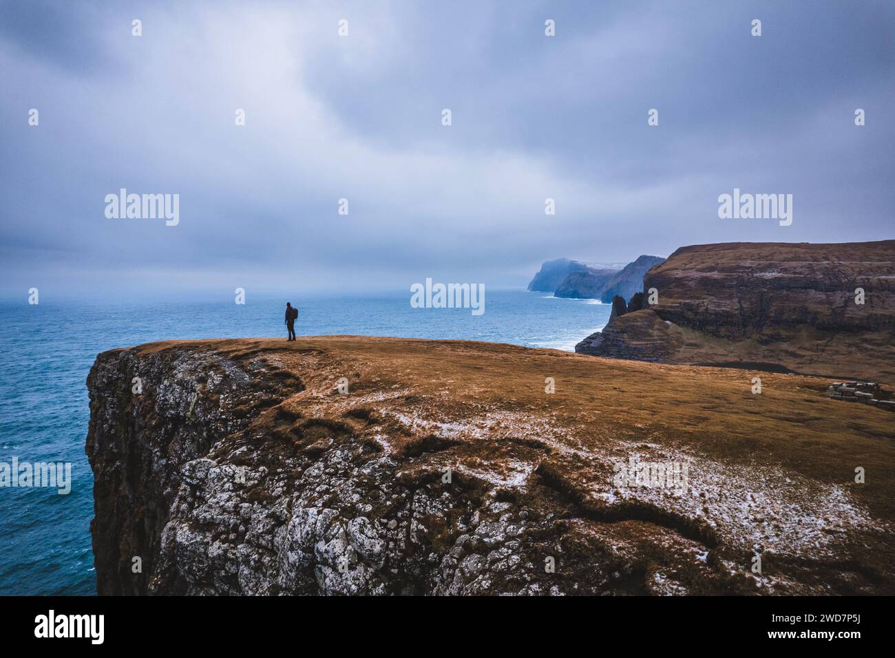 El hombre está aislado solo en la cima del acantilado del océano, Islas Feroe Foto de stock