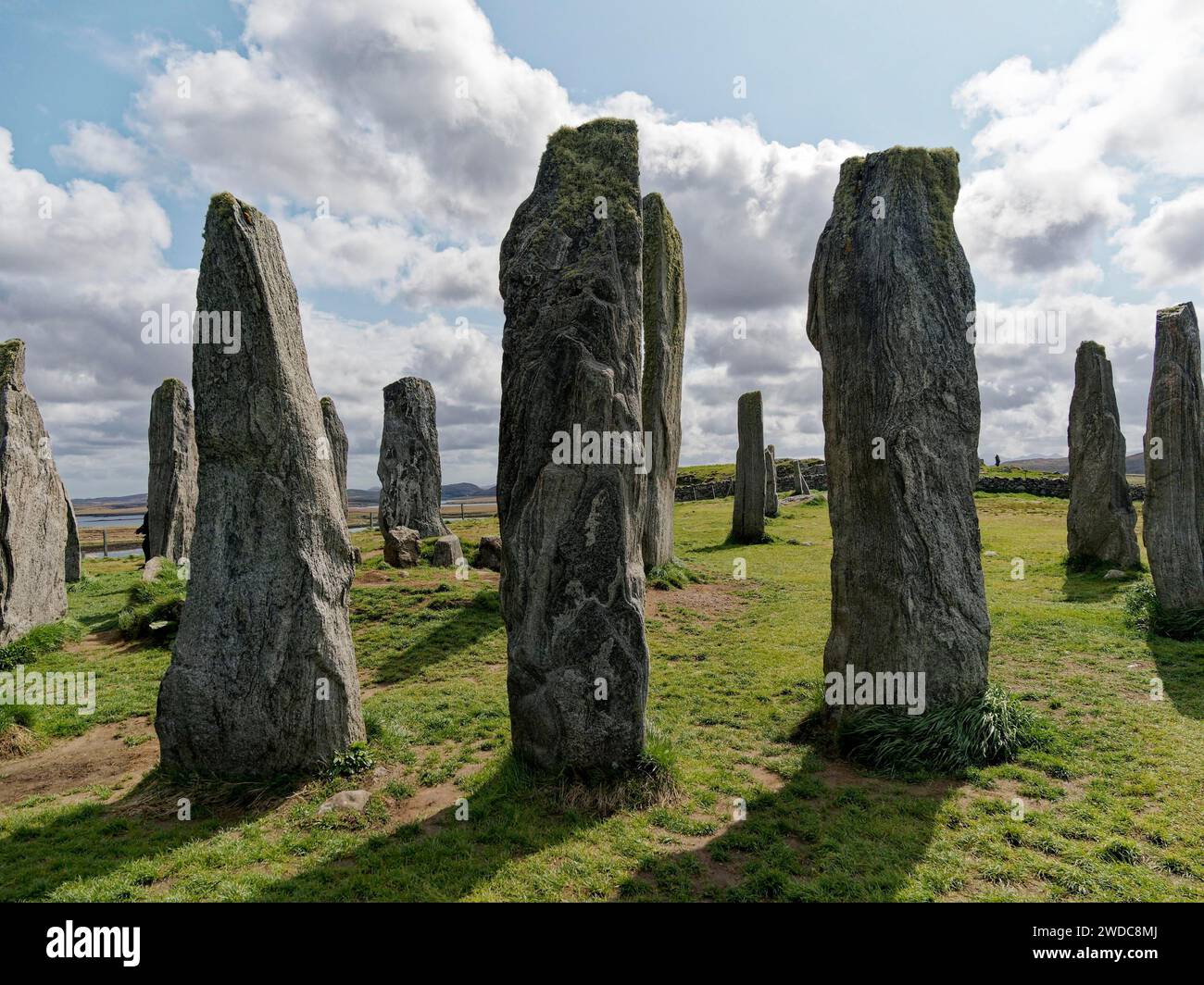 Los monumentos de piedra se elevan en un prado verde bajo un cielo ...
