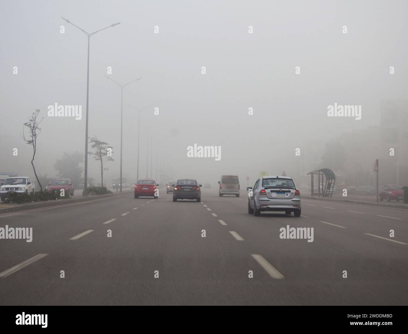 El CAIRO, Egipto, 31 de diciembre de 2023: Poca visibilidad en una carretera de conducción en Egipto en la mañana temprana, pronóstico del estado del tiempo de niebla, niebla o ha Foto de stock