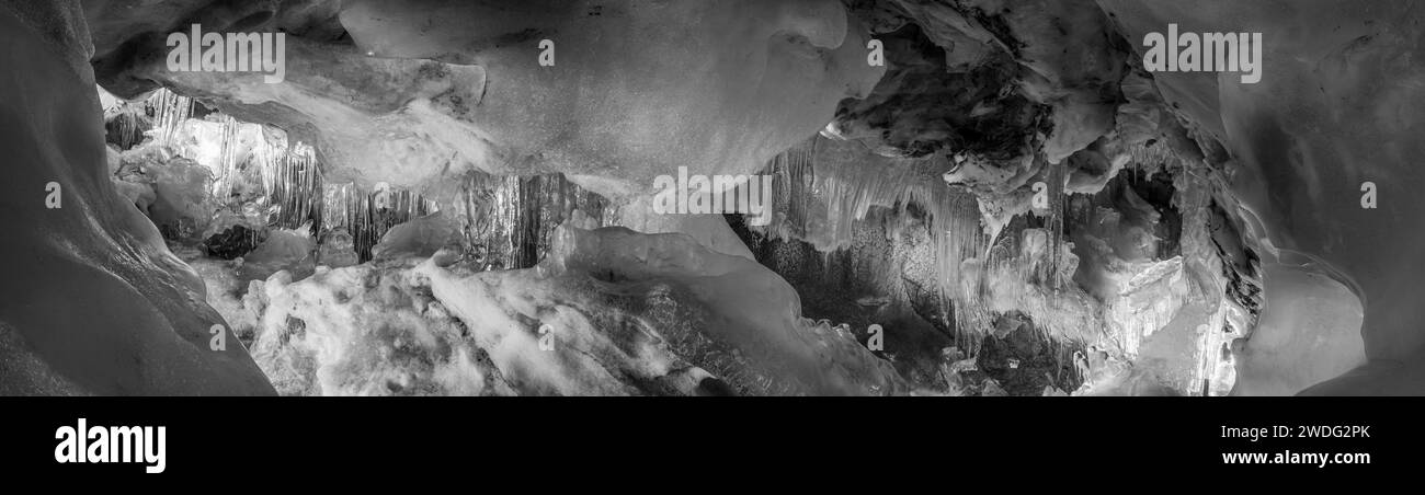 Gran formación de hielo en una pequeña cueva glaciar natural Foto de stock
