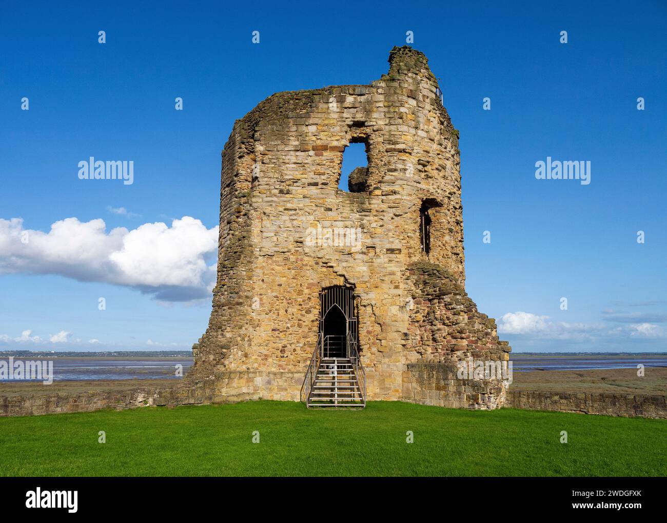 Torre de esquina oriental de tres pisos en ruinas del castillo de Flint en un día soleado, con vistas a través del estuario de Dee hacia Inglaterra; Flint, Flintshire, Gales Foto de stock