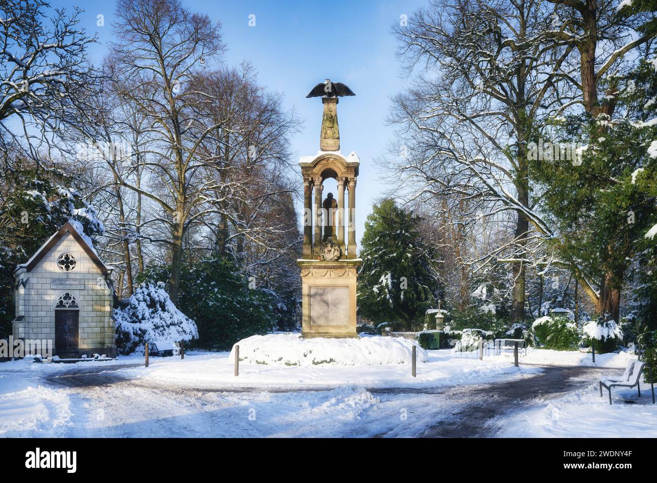 la plaza central con la columna de águila del cementerio melaten de colonia cubierta de nieve Foto de stock