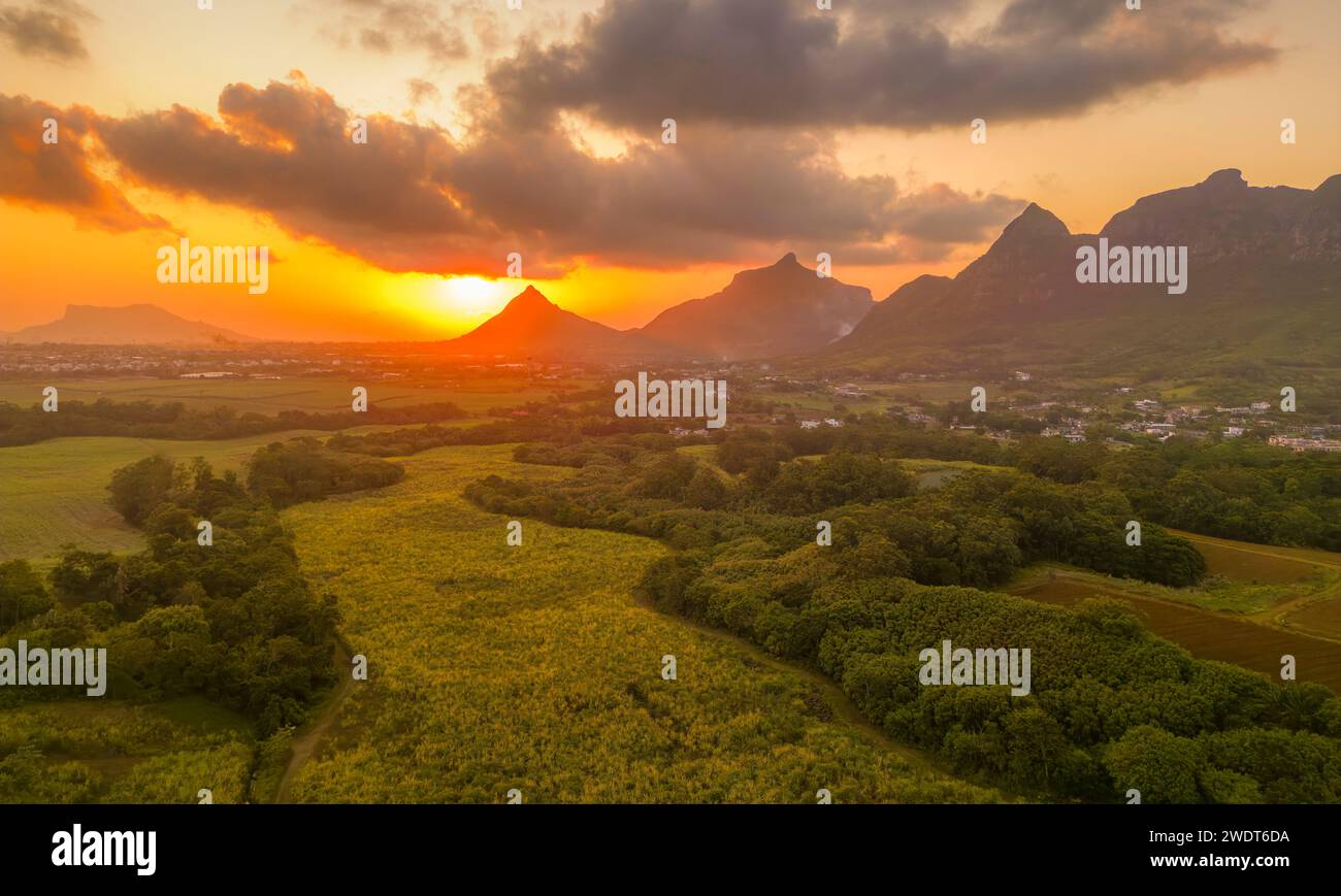 Vista de la puesta de sol dorada detrás de Long Mountain y mosaico de campos verdes, Mauricio, Océano Índico, África Foto de stock