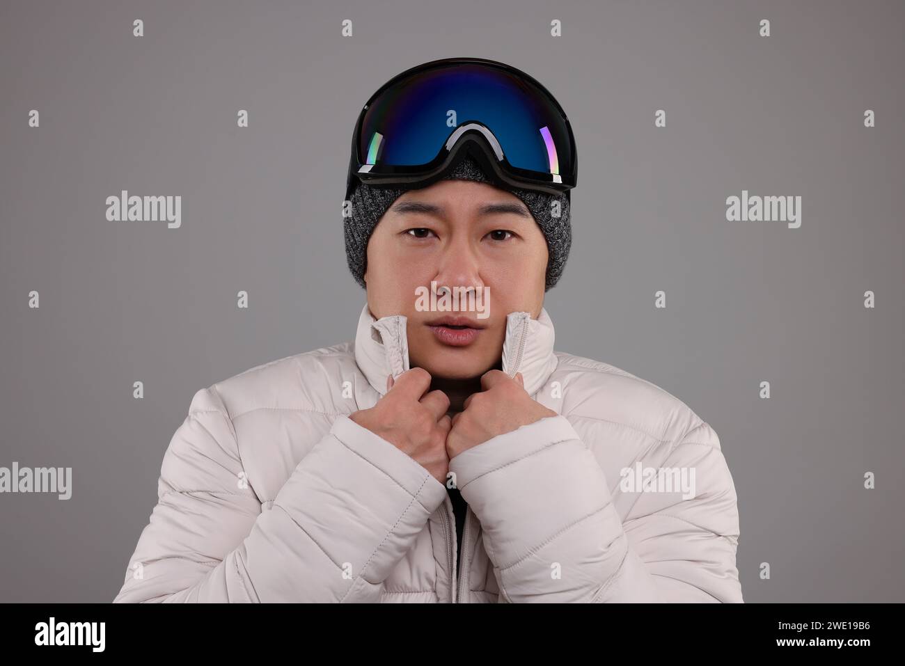 Deportes de invierno. Hombre con gafas de esquí sobre fondo gris Foto de stock