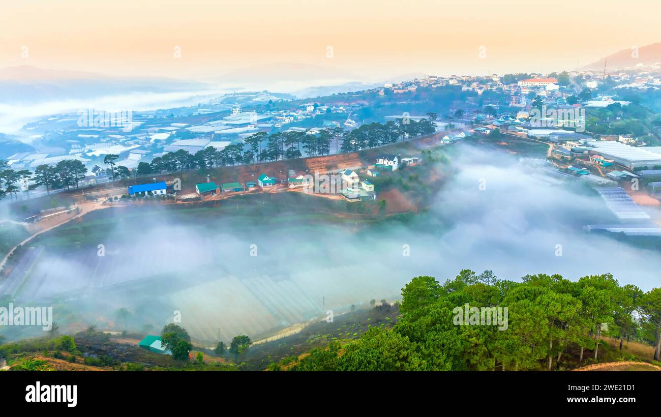 Vista aérea de los suburbios de Xuan Tho cerca de la ciudad de Da Lat por la mañana con cielo brumoso y de salida del sol. Este lugar es considerado el lugar más hermoso y tranquilo Foto de stock