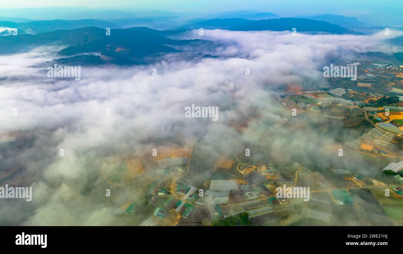 Vista aérea de los suburbios de Xuan Tho cerca de la ciudad de Da Lat por la mañana con cielo brumoso en las tierras altas de Vietnam. Textura de desarrollo urbano, transporte Foto de stock